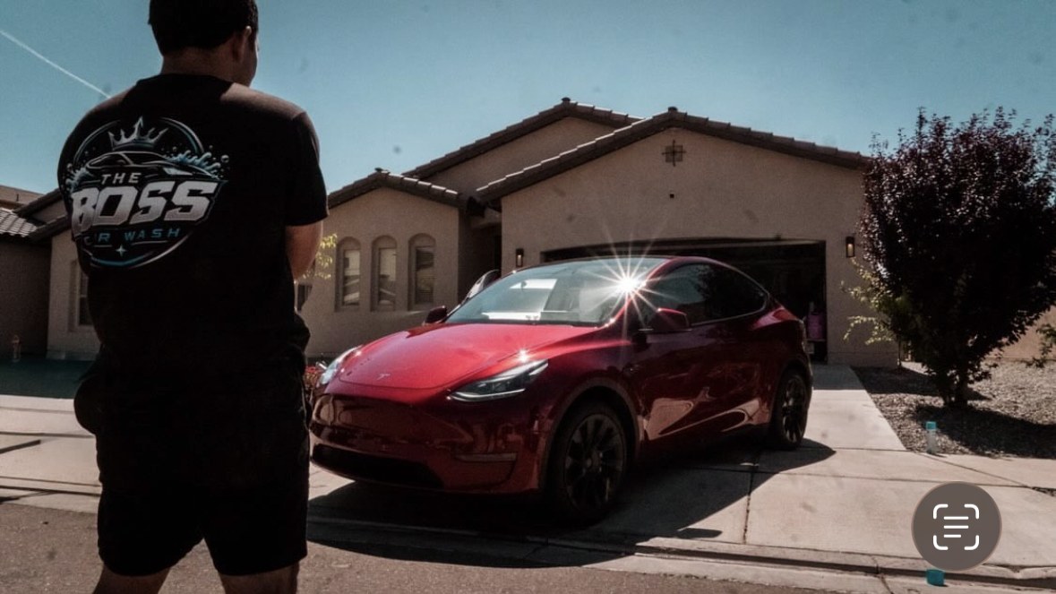 The Boss next to a freshly detailed red Tesla